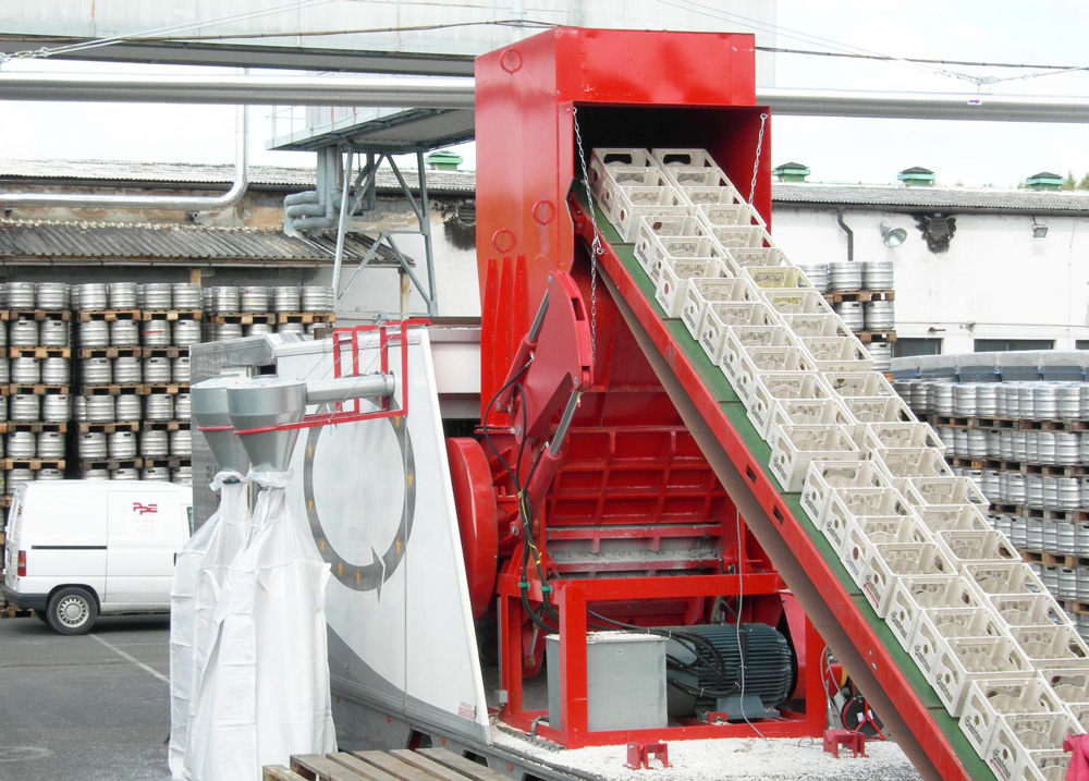 A bright red recycling machine used to process plastic crates